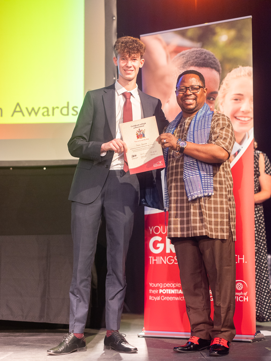 Platon, a new Year 12 student stood with his award certificate and a prize giver