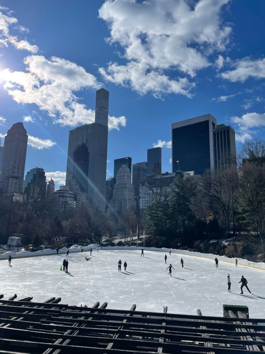 A landscape view of some skyscrapers behind an ice rink