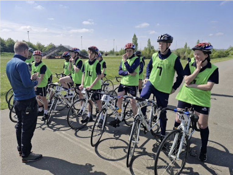 Students stood in a row on their bikes talking to an instructor