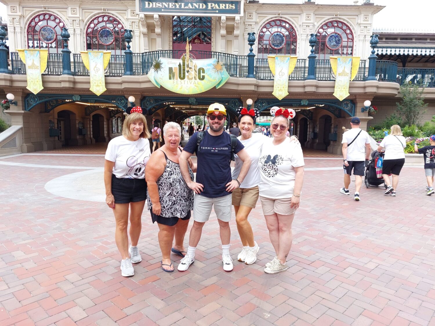 Five adults pose for a picture at Disneyland