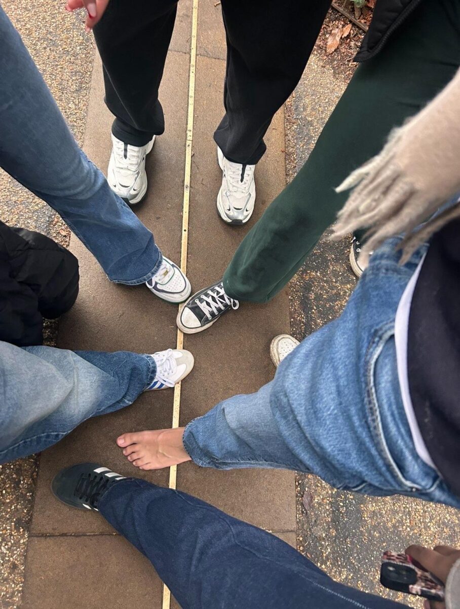 Picture shows people's shoes standing on the GMT line in Greenwich