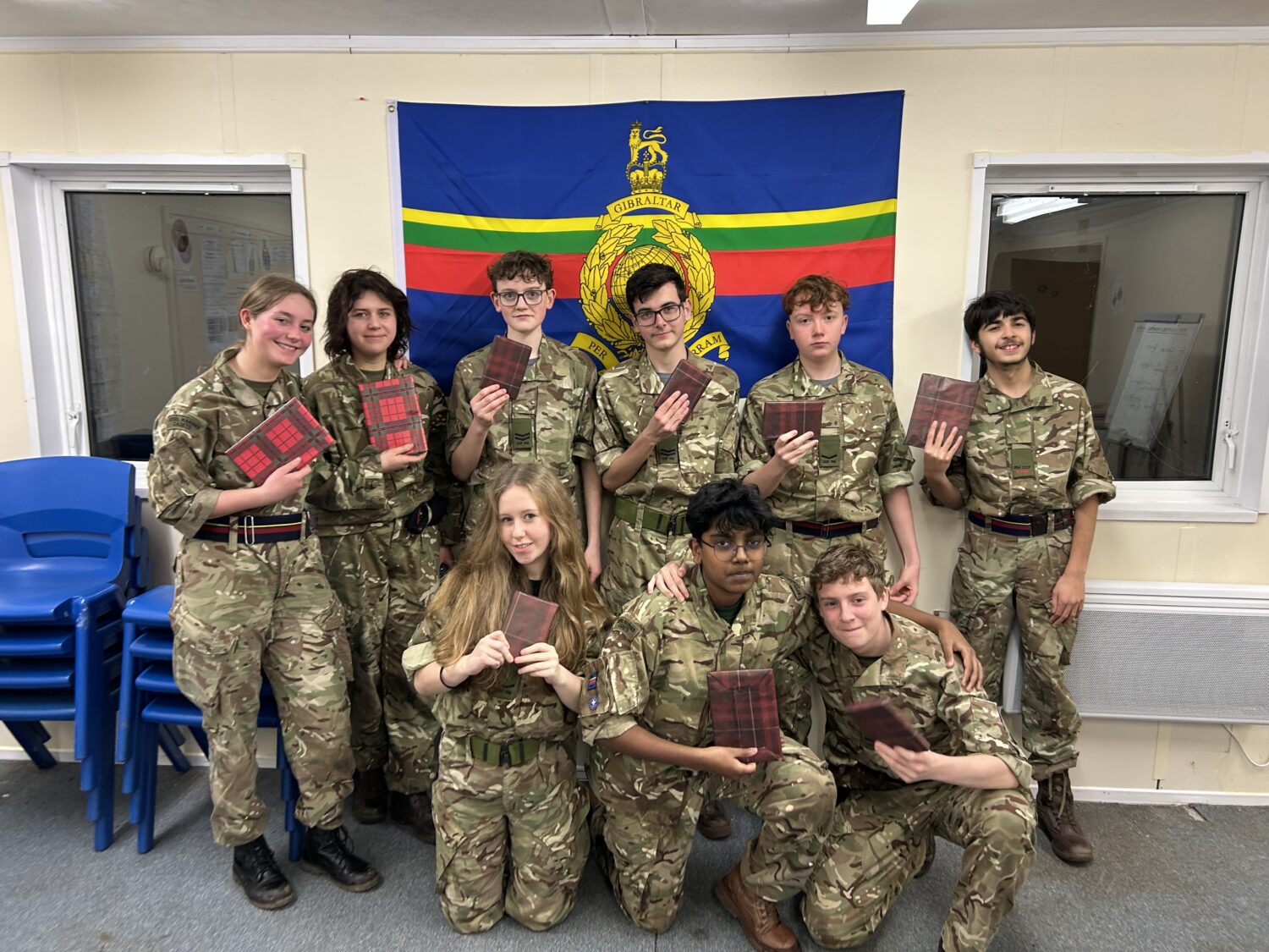 a group of cadets all holding wrapped gifts
