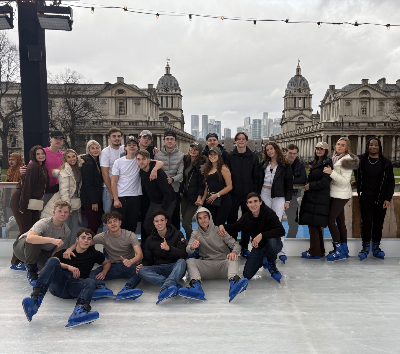 A Group of students pose for a picture at an outdoor ice rink