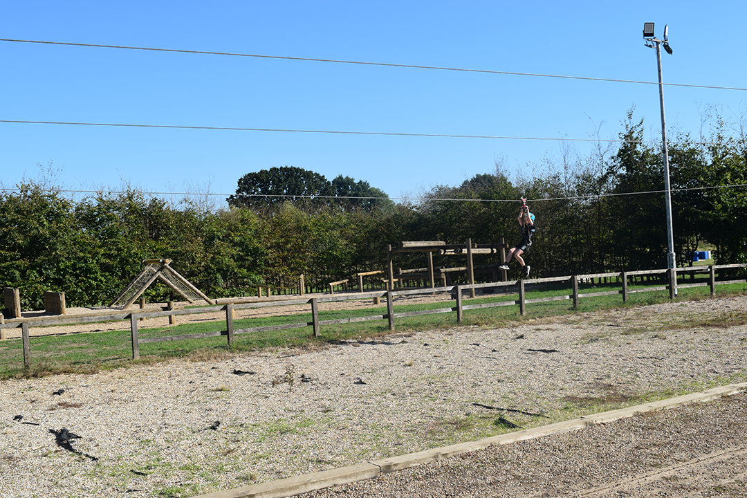 A child going down a zip line in a outdoor setting