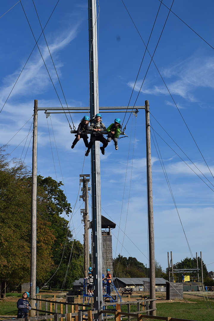 Three people attached to a giant swing