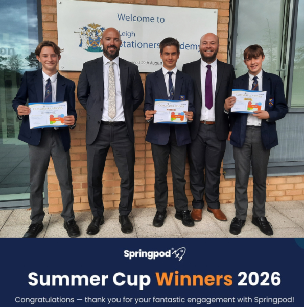 Three students in academy uniform hold congratulations certificates, standing with two staff members outside the Leigh Stationers' Academy entrance sign. A banner below reads: "Springpod Summer Cup Winners 2026. Congratulations, thank you for your fantastic engagement with Springpod!"